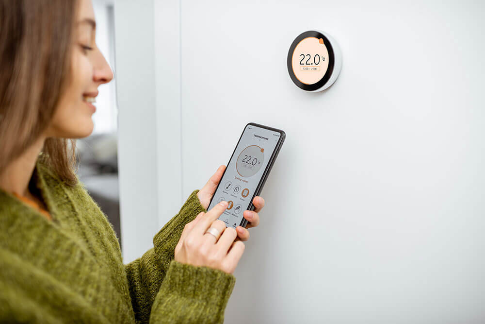 Woman controlling a smart thermostat
