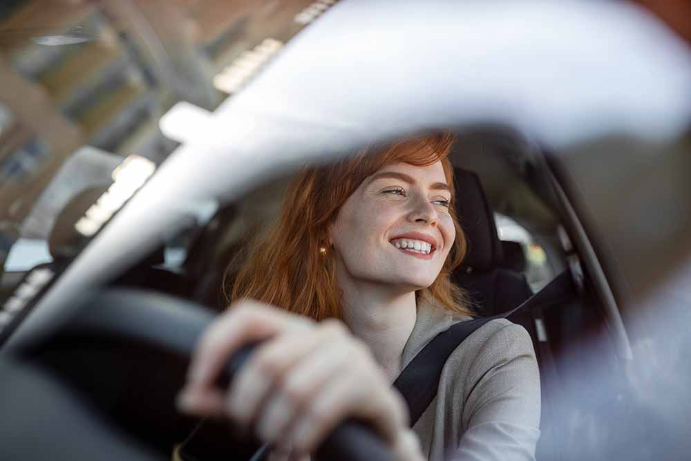 Smiling woman behind the wheel of a car