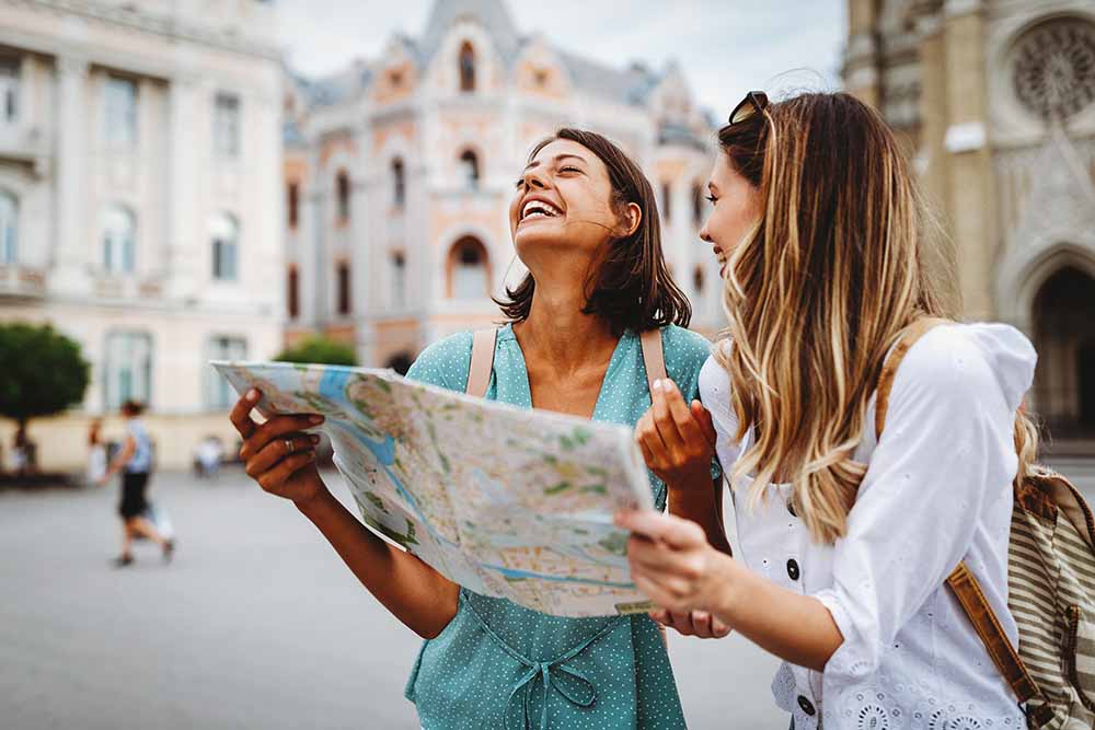Two young women looking at a map in a European town