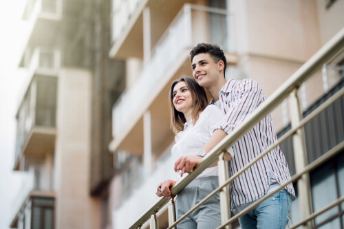 Jeune couple assis au balcon d’une copropriété