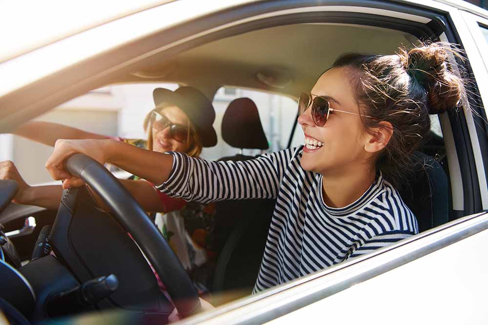 Two young women driving in a car